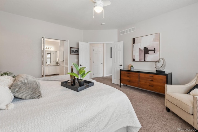 carpeted bedroom with a ceiling fan, visible vents, and ensuite bathroom