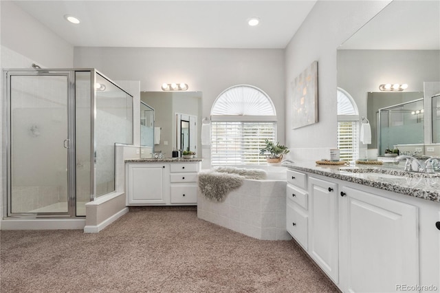 full bath featuring carpet flooring, two vanities, a stall shower, and a sink