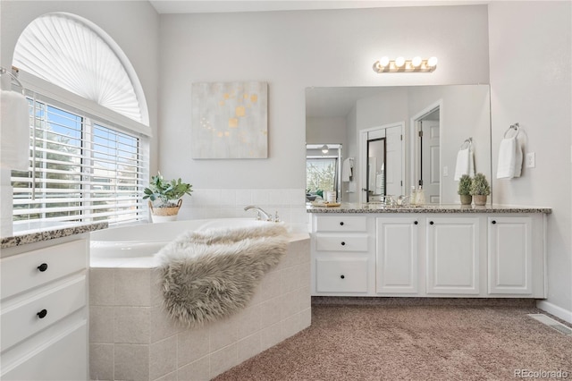 full bathroom with visible vents, a garden tub, and vanity