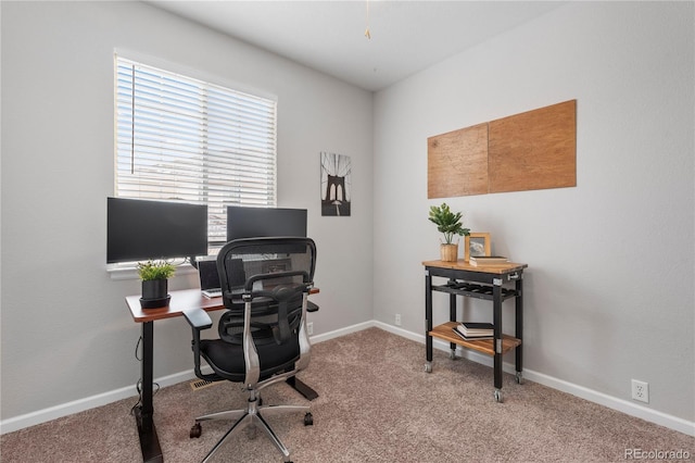 carpeted home office featuring baseboards