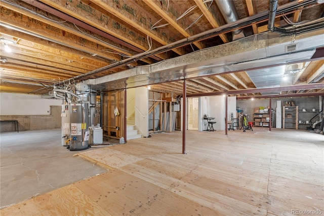 unfinished below grade area with visible vents, gas water heater, and stairs