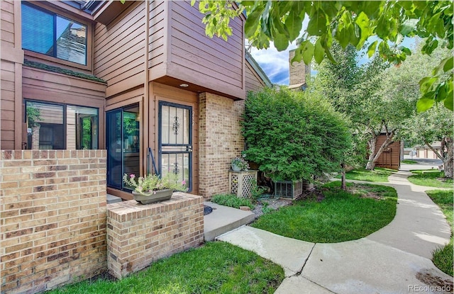 view of exterior entry with brick siding