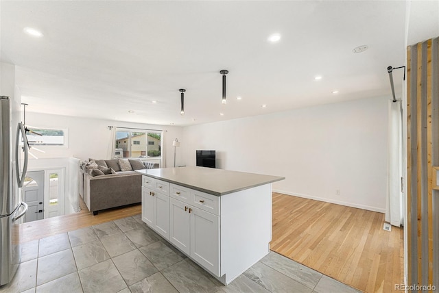 9265 Newton St, Westminster, CO 80031 - kitchen with open floor plan, freestanding refrigerator, white cabinets, recessed lighting, and a kitchen island
