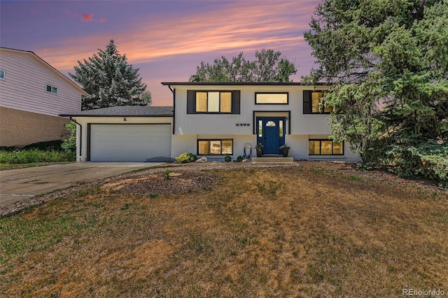 9265 Newton St, Westminster, CO 80031 - raised ranch featuring a garage, driveway, a front yard, and brick siding