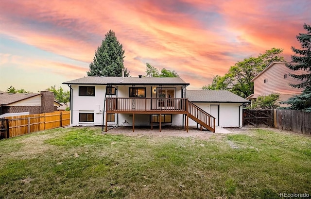 9265 Newton St, Westminster, CO 80031 - back of property at dusk with stairway, a fenced backyard, and a wooden deck