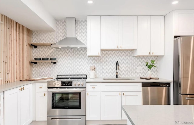 9265 Newton St, Westminster, CO 80031 - kitchen with stainless steel appliances, wall chimney range hood, light countertops, tasteful backsplash, and recessed lighting