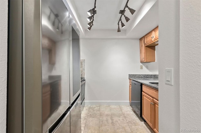 kitchen with track lighting, a raised ceiling, black dishwasher, and stainless steel fridge