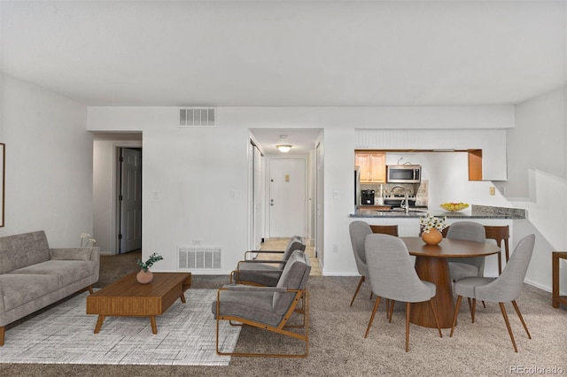 living room with light colored carpet and sink