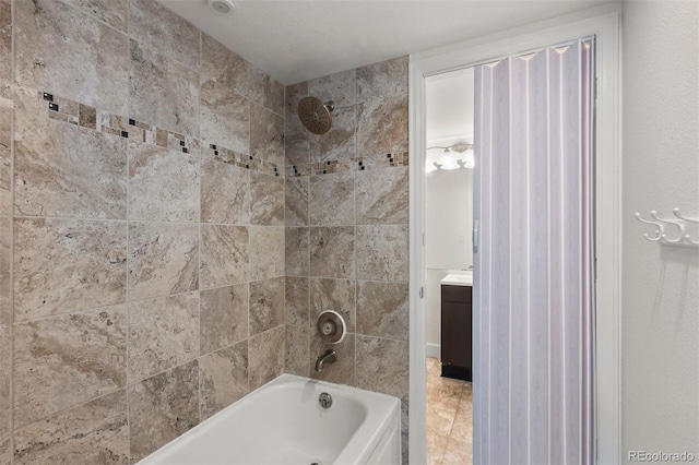 bathroom with tiled shower / bath and vanity