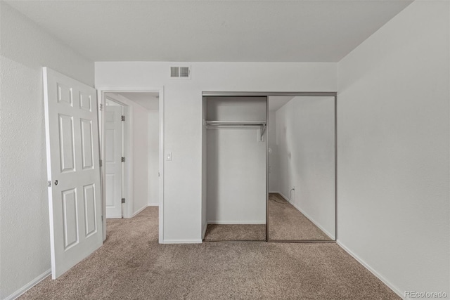 unfurnished bedroom with a closet and carpet flooring