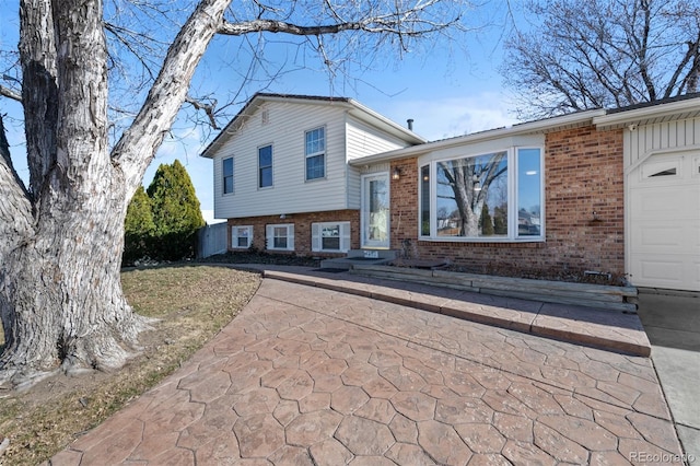 split level home with a garage and brick siding