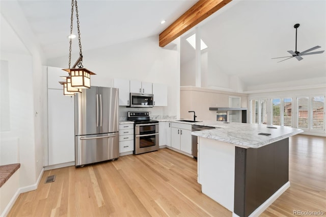 1904 S Union Pl, Lakewood, CO 80228 - kitchen with appliances with stainless steel finishes, high vaulted ceiling, a peninsula, beam ceiling, and decorative light fixtures