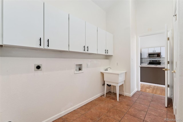 1904 S Union Pl, Lakewood, CO 80228 - washroom featuring cabinet space, electric dryer hookup, washer hookup, baseboards, and a high ceiling