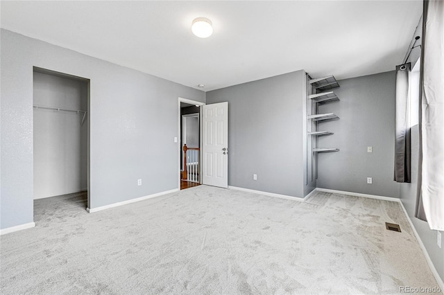 unfurnished bedroom featuring light carpet and a closet