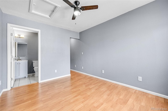 unfurnished bedroom featuring ceiling fan, connected bathroom, and light hardwood / wood-style flooring