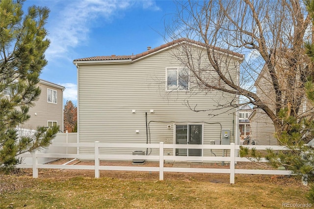 rear view of property featuring a lawn