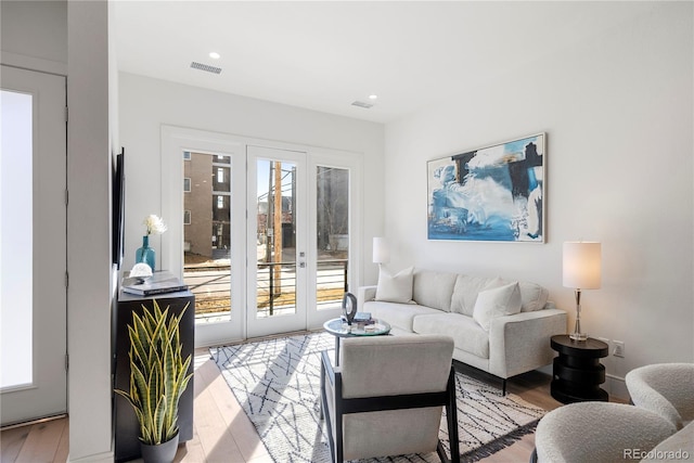 living area featuring recessed lighting, visible vents, and wood finished floors