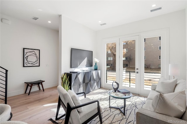 living area featuring light wood-style floors, recessed lighting, visible vents, and baseboards