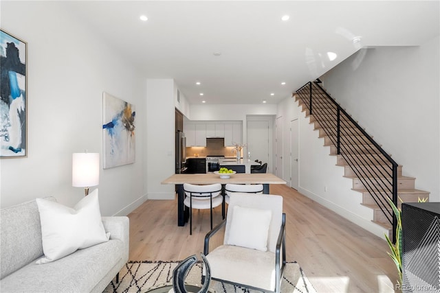 living room with light wood finished floors, stairs, baseboards, and recessed lighting