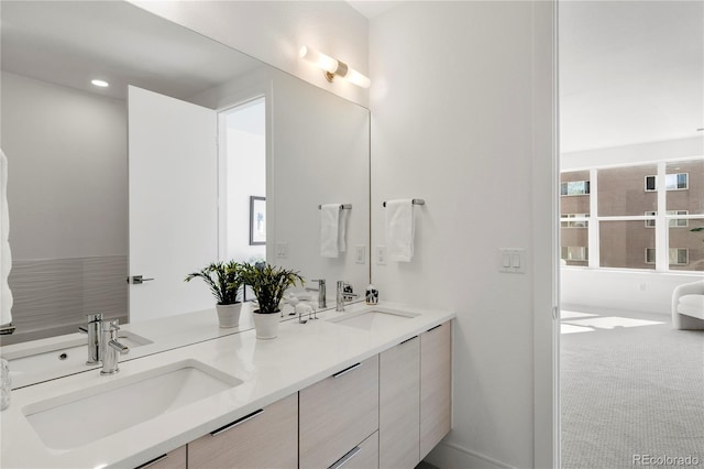 bathroom with double vanity, a sink, and recessed lighting