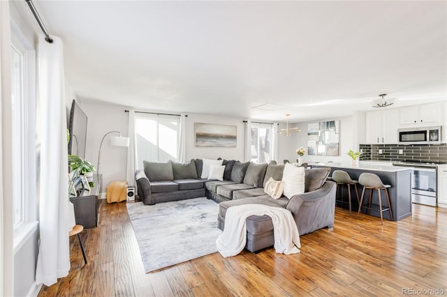 living room featuring an inviting chandelier and light hardwood / wood-style flooring