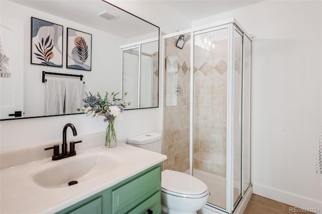 bathroom with vanity, tile patterned floors, a shower with door, and toilet