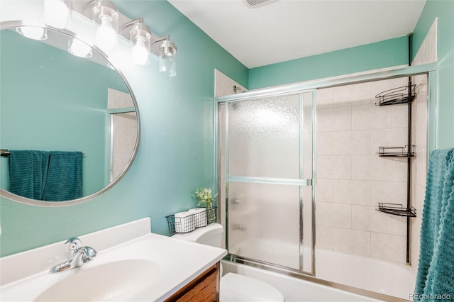 full bathroom with toilet, vanity, and shower / bath combination with glass door