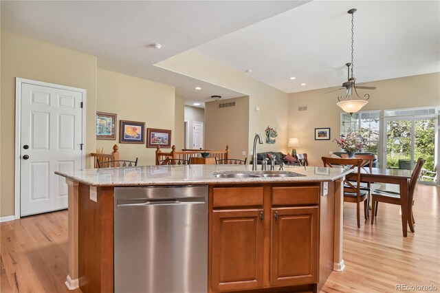 23285 Chapel Hill Ln, Parker, CO 80138 - kitchen featuring dishwasher, light wood finished floors, light stone countertops, brown cabinetry, and an island with sink