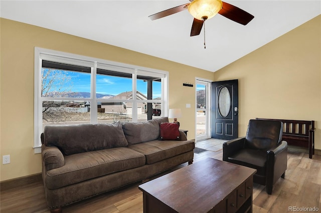 living area with ceiling fan, light wood finished floors, and lofted ceiling