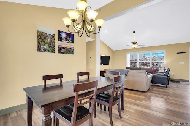 dining area featuring light wood-type flooring, baseboards, ceiling fan with notable chandelier, and lofted ceiling