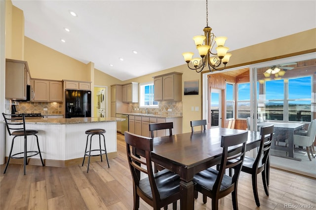 dining space featuring light wood-style floors, recessed lighting, a chandelier, and vaulted ceiling