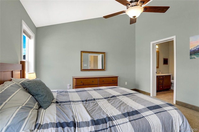 bedroom with baseboards, light colored carpet, high vaulted ceiling, and ensuite bath