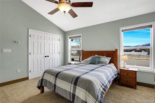 bedroom featuring baseboards, light colored carpet, lofted ceiling, and a closet