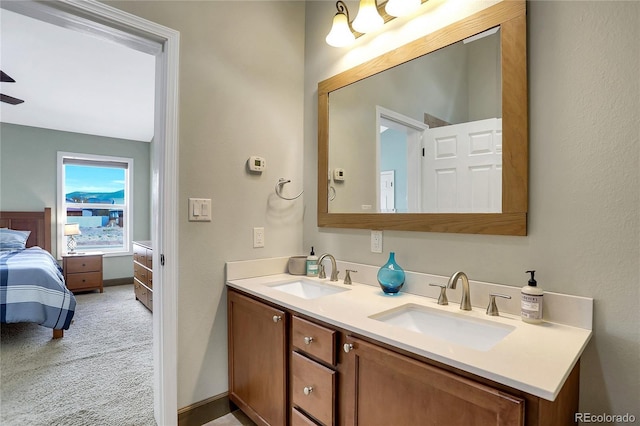 bathroom with double vanity, a sink, ceiling fan, and ensuite bath