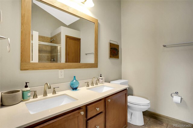 bathroom featuring double vanity, toilet, a sink, and a stall shower