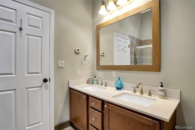 full bath with double vanity, a shower stall, and a sink