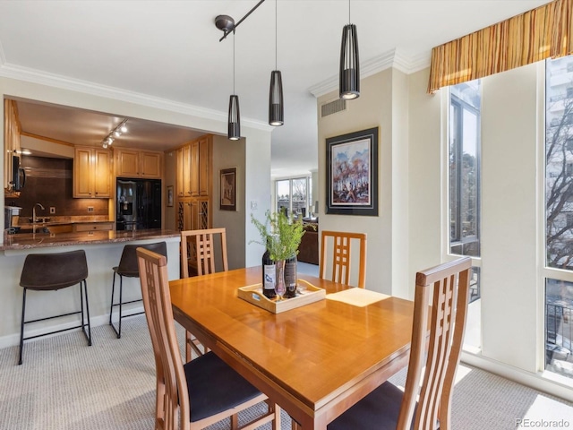 dining area featuring visible vents, light colored carpet, ornamental molding, and rail lighting