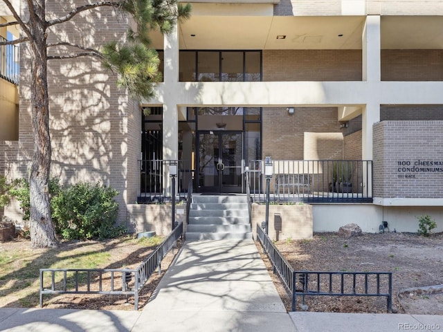 view of exterior entry featuring french doors and brick siding