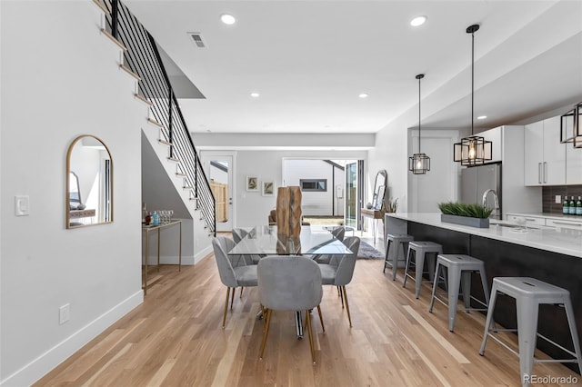 dining room with sink and light wood-type flooring