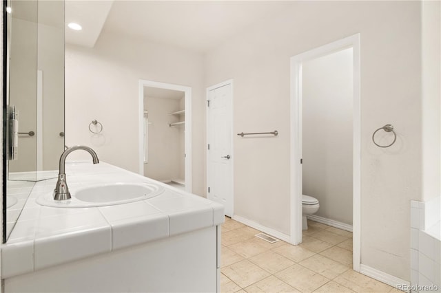 14032 E Chenango Dr, Aurora, CO 80015 - bathroom featuring double vanity, toilet, recessed lighting, tile patterned floors, and baseboards