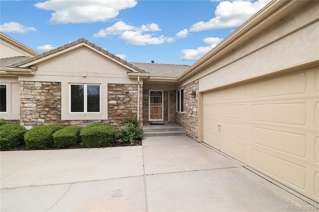 14032 E Chenango Dr, Aurora, CO 80015 - view of front of house with stone siding, a tile roof, stucco siding, and a garage