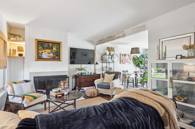 living room with a glass covered fireplace and wood finished floors