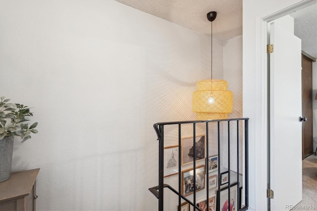 stairway featuring a textured ceiling