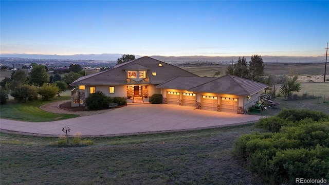 view of front of house with a mountain view, a yard, and a garage