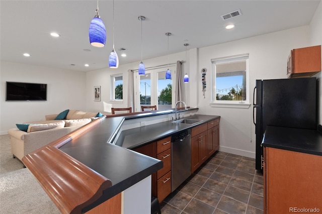 kitchen with black fridge, hanging light fixtures, stainless steel dishwasher, and sink