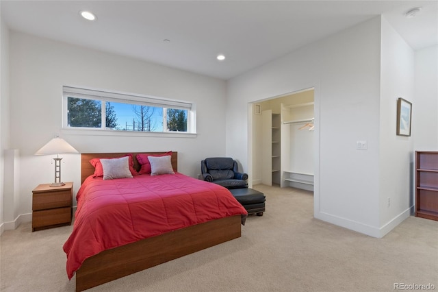 carpeted bedroom with a spacious closet and a closet