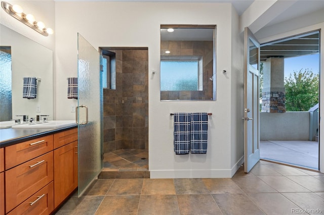 bathroom featuring tile patterned flooring, vanity, and tiled shower