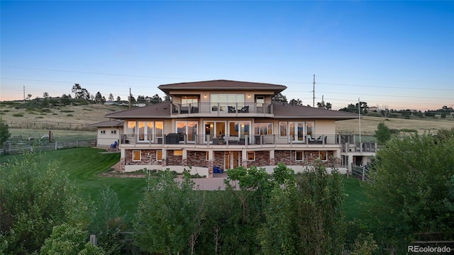 back of house with a lawn, a balcony, and a patio