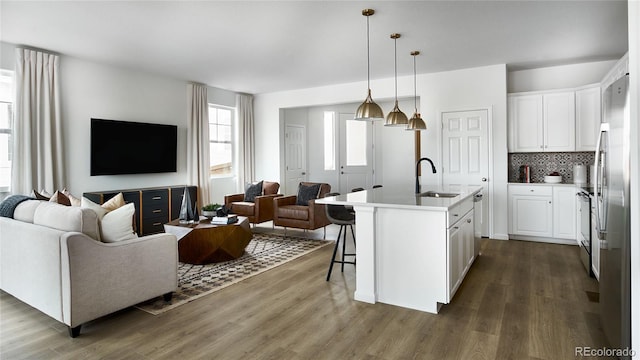 kitchen featuring white cabinetry, sink, pendant lighting, and a center island with sink