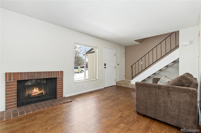 living room featuring hardwood / wood-style flooring, a fireplace, and a textured ceiling